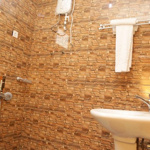 Executive room: bathroom with stone-tiled wall